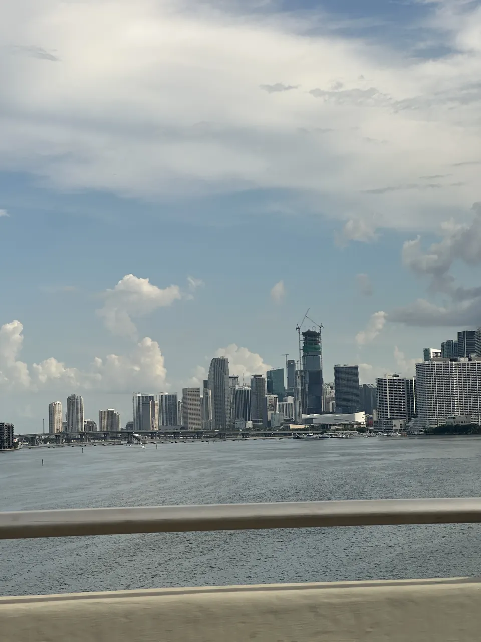 Su üzerinden görünen Miami gökdelenleri ve bulutlu gökyüzü.