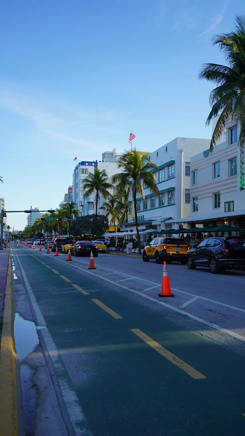 Ocean Drive boyunca sıralanan açık renkli binalar, palmiyeler ve cadde.
